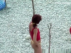 Nudists preparing their spot in the rocky beach