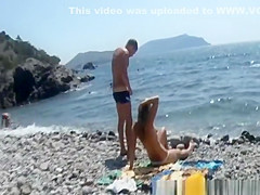 Women topless at rocky beach