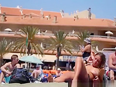 Girl with pierced belly topless at the beach