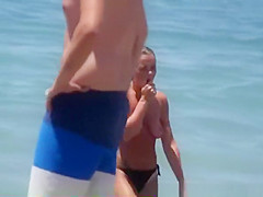 Girl with pierced belly topless at the beach