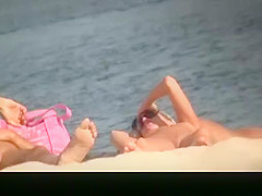Nude woman in nudist beach sunbathing