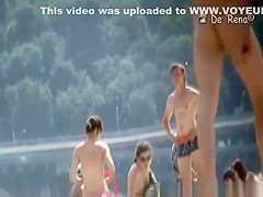 Nudist couple by the water