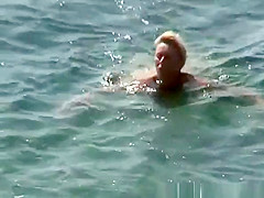 Mature nudist woman swimming
