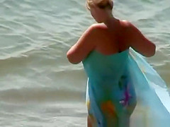 Mature nudist woman swimming