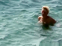 Mature nudist woman swimming