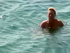Mature nudist woman swimming