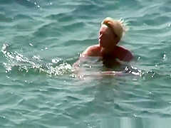 Mature nudist woman swimming