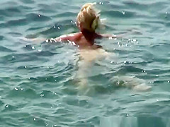 Mature nudist woman swimming