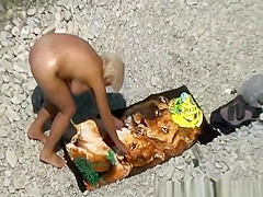 Mature woman sunbathing in rocky beach