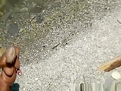 Mature woman sunbathing in rocky beach