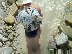 Naked woman in rocky beach