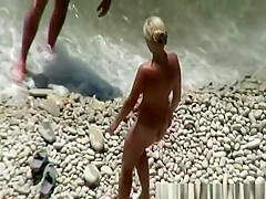 Busty blonde nudist swimming in the water