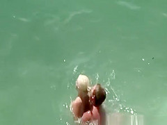 Busty blonde nudist swimming in the water