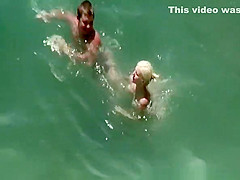 Busty blonde nudist swimming in the water