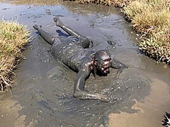 Sexy Girl Playing In The River Mud. Muddy Fun (fully Clothed)
