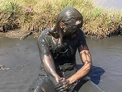 Sexy Girl Playing In The River Mud. Muddy Fun (fully Clothed)