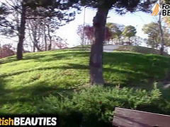 Barefoot brunette takes off socks, shows feet in a park