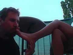 Sexy femdom smoking a cigarette while getting feet licked and toes sucked by Foot Girls